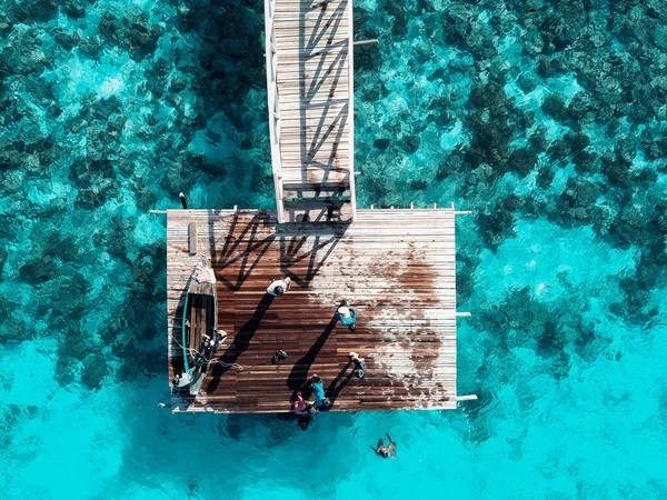 Tahta Jetty 'nin sonunda, üzerinde kimliği belirsiz çocuklar olan tepeden aşağı hava manzarası..