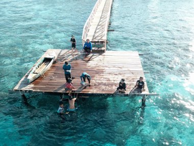 Semporna, Borneo Sabah, Malezya 'daki iskelede oynayan çocukların hava görüntüsü.