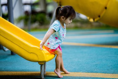 Küçük şirin Asyalı 2-3 yaşında, çocuk parkında küçük bir kız çocuğu. 