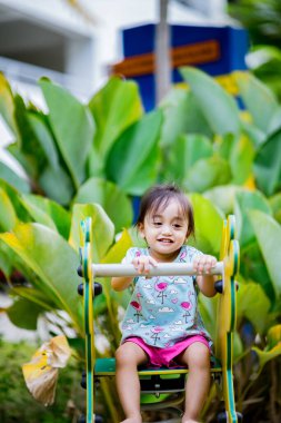 Küçük şirin Asyalı 2-3 yaşında, çocuk parkında küçük bir kız çocuğu. 