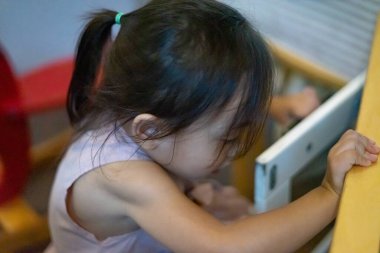 Küçük sevimli Asyalı çocuk evde oyuncaklarla oynuyor. Yüksek açı görünümü.