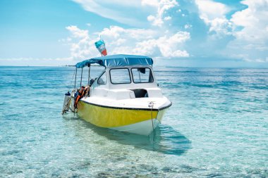 Sabah bayraklı tekne, Malezya 'nın Borneo kentindeki Semporna cennet adasında güneşli, mavi gökyüzü gününde, kristal berrak turkuaz suyla çevrili. Yatay kopyalama alanı