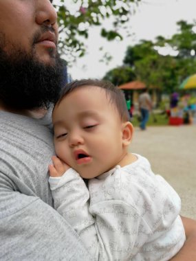 Baba ve bebek parkta omuzlarında