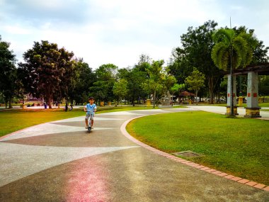 Motosikletli ve parkta bir çocuk. Sağlıklı yaşam tarzı ve spor eğlencesi kavramı.