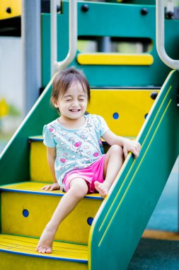 Küçük şirin Asyalı 2-3 yaşında, çocuk parkında küçük bir kız çocuğu. 