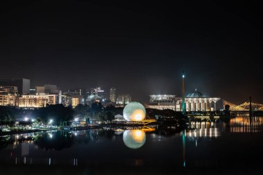 Renkli camili gece sahnesi, sıcak hava balonu ve Putrajaya, Malezya 'daki nehir yansımalı köprü..