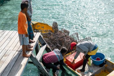 Semporna, Malezya - 26 Kasım 2019: Balıkçı çiğ balıklarını Egang 'daki dağ evinin mutfağına satıyor - Egang Resort, Bum Bum Adası, Sabah,.