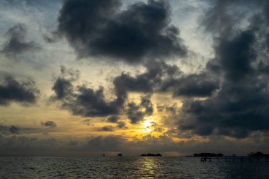 Günbatımı arka plan ve açık denizde güneş ışığı güzel bulutlarla.
