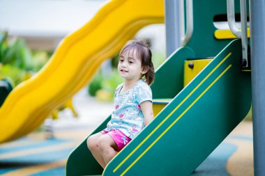 Küçük şirin Asyalı 2-3 yaşında, çocuk parkında küçük bir kız çocuğu. 