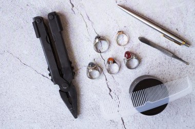 Şık erkek yüzükleri, kalem, aletler, mendil, poz ve tımar için parfüm. Beton arka planda metroseksüel sezaryenler. Şehir kompozisyonu. Üst görünüm.