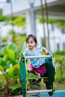 Küçük şirin Asyalı 2-3 yaşında, çocuk parkında küçük bir kız çocuğu. 