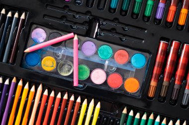 Masa başı görünümünde malzemeler, okul yaratıcı işleri için yaratıcı araçlar, boyama kağıtları, boya fırçaları kalem boyaları, resim malzemeleriyle arka plan,