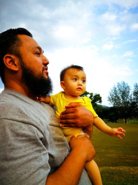 Baba ve oğlu arka planda.