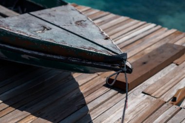 İskelede duran eski ahşap tekne güzel Semporna turkuaz denizine bakıyor..