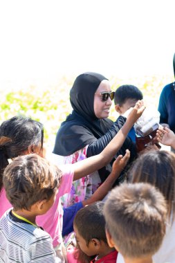 Sibuan, Malezya - 26 Kasım 2019: Köydeki Bajau Laut çocuklarına atıştırmalık ve mal dağıtan ziyaretçiler.