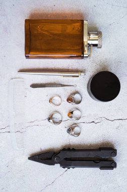 Şık erkek yüzükleri, kalem, aletler, mendil, poz ve tımar için parfüm. Beton arka planda metroseksüel sezaryenler. Şehir kompozisyonu. Üst görünüm.