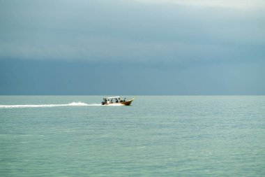 LumPerak, Malezya - 16 Eylül 2019: Hızlı hareket eden taşımacılık teknesindeki insanlar denizi geçiyor.