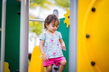 Küçük şirin Asyalı 2-3 yaşında, çocuk parkında küçük bir kız çocuğu. 