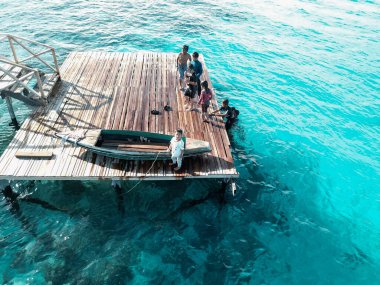 Semporna, Borneo Sabah, Malezya 'daki iskelede oynayan çocukların hava görüntüsü.