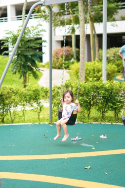 Çocuk parkında salıncakta sallanan küçük bir çocuğun bulanık fotoğrafı. Mutlu ve eğlenceli zaman.