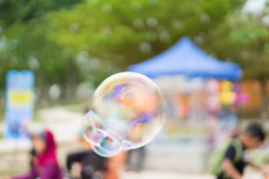 Bahçede yüzen sabun köpüklerinin bulanık fotoğrafı..