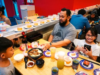 Nilai, Malezya - 3 Haziran 2019: Aileler Aeon NIlai, Negeri Sembilan 'daki Restoran Suşi Kralı' nda Japon yemeklerini yiyorlar.