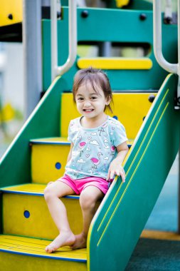 Küçük şirin Asyalı 2-3 yaşında, çocuk parkında küçük bir kız çocuğu. 