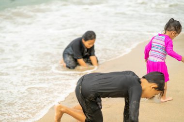 Genç Asyalı çocuklar sahilde oynuyorlar. Tatil ve rahatlama kavramı.