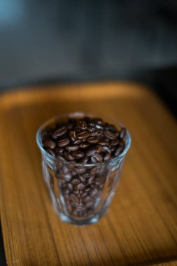 Bardaktaki kahve çekirdekleri ahşap arka planda..