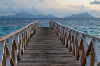 Borneo Sabah Semporna 'daki Bum bum adasının yakınındaki günbatımında tahta köprü..