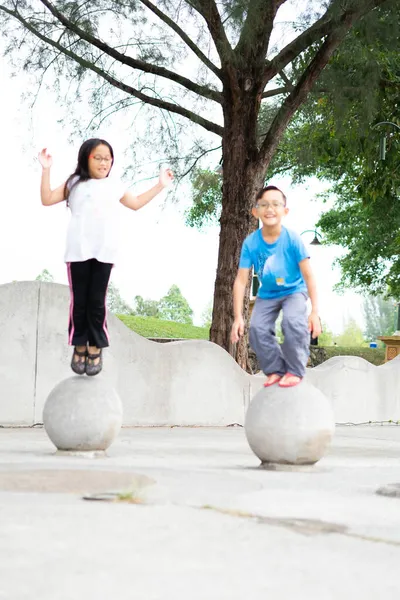 공원에 콘크리트 공에서 뛰어내린 귀여운 말레이시아 아이들의 — 스톡 사진