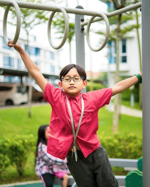 若いアジアの子供たちはサルのバーにかかっている 近所の屋外遊び場で運動するには — ストック写真