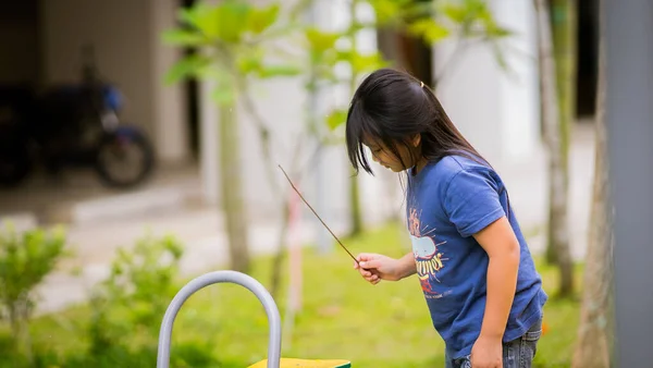 一个留长发的年轻亚洲女孩在公园里玩耍 — 图库照片