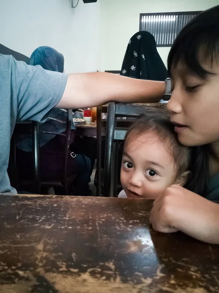 Asian family in a restaurant waiting for breakfast.