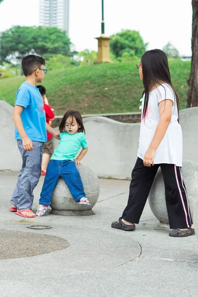 Azjatyckie Dzieci Siedzące Betonowej Kuli Parku — Zdjęcie stockowe