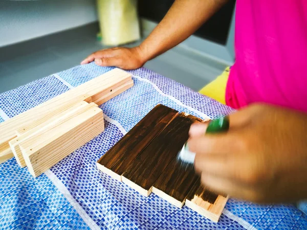 Szczotka Rąk Pokazuje Jak Nakładać Brązową Plamę Mahoniową Deski Drewniane — Zdjęcie stockowe