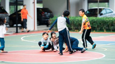 Bangi, Malezya - 10 Temmuz 2019: Çocuklar beyzbol sahasında mutlu bir şekilde oynuyorlar. Toplum çocukları birlikte oynuyorlar..