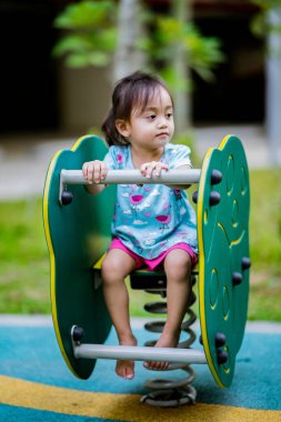 Küçük şirin Asyalı 2-3 yaşında, çocuk parkında küçük bir kız çocuğu. 