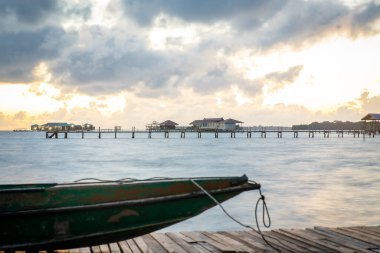 İskelede duran eski ahşap tekne güzel Semporna turkuaz denizine bakıyor..