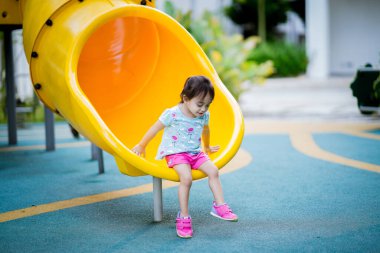 Küçük şirin Asyalı 2-3 yaşında, çocuk parkında küçük bir kız çocuğu. 