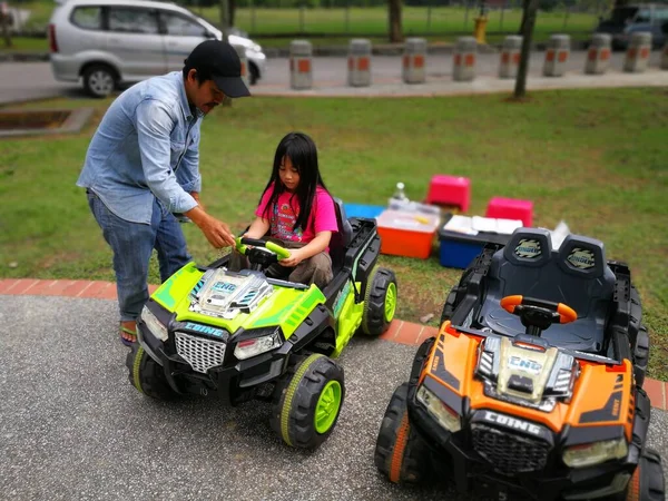 公園でおもちゃの車を運転している女の子 — ストック写真