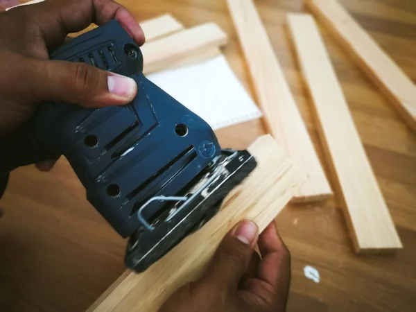 Foto Uma Mão Lixando Madeira Com Uma Máquina Oficina Artesão — Fotografia de Stock