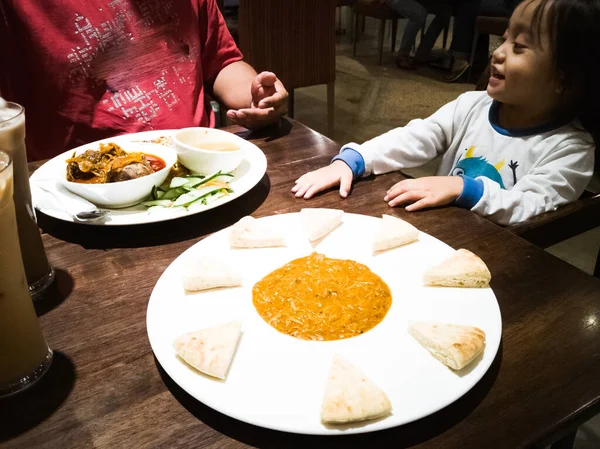 Asyalı baba ve bebek Arap restoranında akşam yemeği.