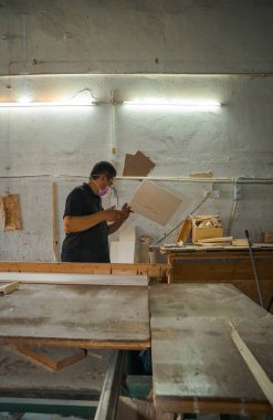 Atölyede maskeyle çalışan bir işçi..