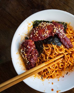 Kore usulü baharatlı tavuk, ramen, hazır şehriye ve kızarmış şehriye ile servis ediliyor..