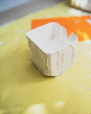 Sarı bir kağıt üzerinde geri dönüştürülmüş süt kutusu kabındaki beyaz boya..