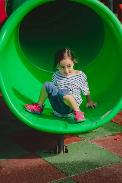 小さな女の子が遊び場で遊んで — ストック写真