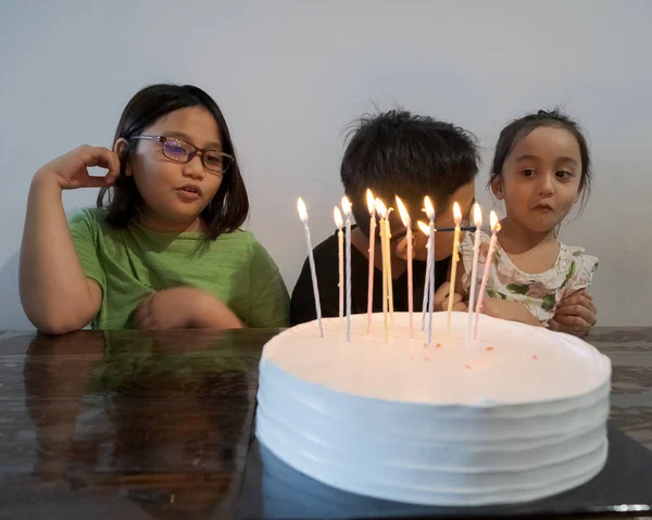 一緒に誕生日を祝う子供たち 白いケーキの上にカラフルなキャンドル — ストック写真