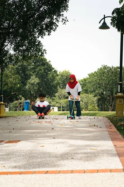 Kinderen Paardrijden Skateboard Scooter Het Park — Stockfoto