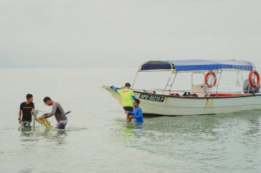 Port Dickson, Malezya - 5 Kasım 2021: İşçiler sabah erkenden nakliye gemisiyle hazırlanıyor.